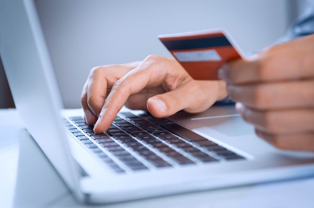 usuário no computador colocando os dados do cartão de crédito para fazer compra online, um dos dos marcos da web 2.0